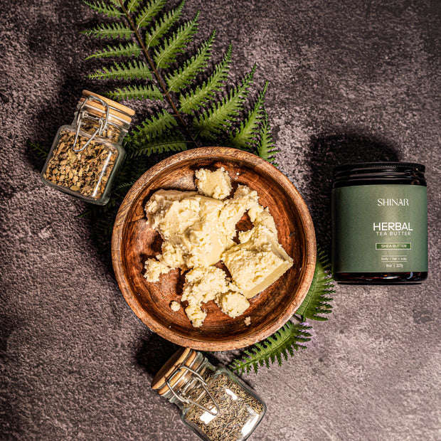Herbal product in a wooden bowl with jars and fern leaves on a dark surface